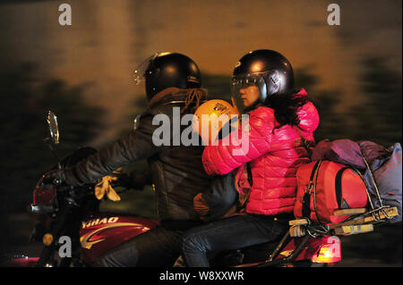 Une famille de migrants chinois conduit une motocyclette sur une route pour rentrer à la maison pour les prochains Nouvel An chinois ou fête du printemps à Foshan City, en Chi Banque D'Images