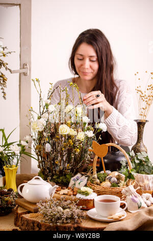 Belle fille sur un set de table pour Pâques. Maison de concept. La vie encore rustique. Banque D'Images