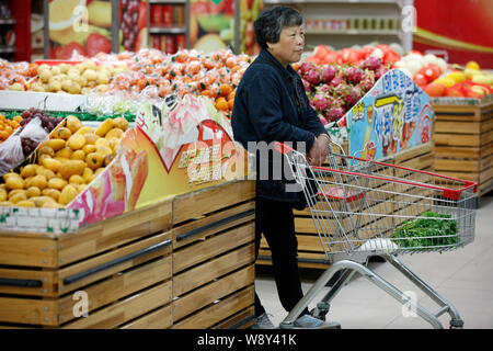 --FILE--un client chinois pousse un panier de fruits au cours des étals d'un supermarché de Huaibei ville, à l'est la province de l'Anhui, Chine 11 avril 2014. Chi Banque D'Images