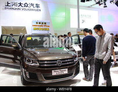 Visiteurs examiner une nouvelle Tiguan de Volkswagen de Shanghai, une joint venture entre SAIC Motor et VW, lors d'une auto de Haikou City, en Chines Haina Banque D'Images