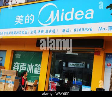 --FILE--un piéton passe devant un magasin de Midea Xuchang ville, province de Henan Chine centrale, 9 novembre 2013. Chinese home appliance retailer Midea Banque D'Images