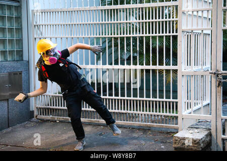 11 août 2019 à Hong Kong. Un jeune manifestant au lance pierre à la police dans les motifs de Tsim Sha Tsui Station de police lors d'affrontements violents entre la police et les manifestants. Banque D'Images