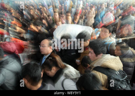 --FILE--un travailleur migrant exerçant ses bagages d'autres passagers et la foule Nantong Railway Station comme ils reviennent au pays pour les Chinois Luna Banque D'Images