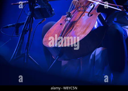 Détail d'un violoncelle instrument de musique en bleu stage lights Banque D'Images