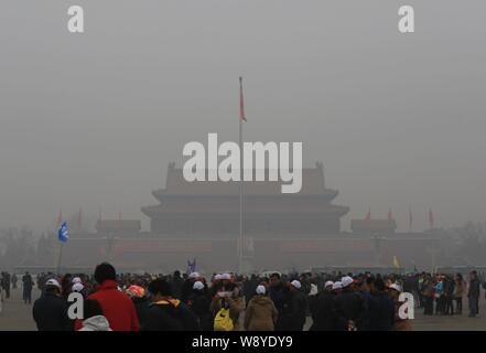 --FILE--touristes visitent la place Tian'anmen dans le smog lourde à Beijing, Chine, 26 février 2014. Les gouvernements de Pékin, Tianjin et Hebei provinc Banque D'Images