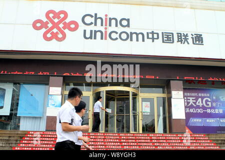 --FILE--piétons passent devant une succursale de China Unicom dans Shanghai, Chine de l'est la province de Shandong, 12 juillet 2014. Électrique américaine Tesla carmaker Mot Banque D'Images