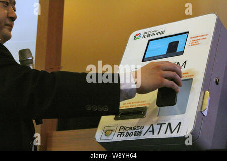 Bobby Lee, PDG de BTC de la Chine, montre le fonctionnement de Chines premier ATM BitCoin lors d'une manifestation de lancement à Shanghai, Chine, le 15 avril 2014. Un Chinois c Banque D'Images