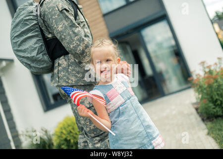 Fille à la maison avec papa de retour de service militaire Banque D'Images