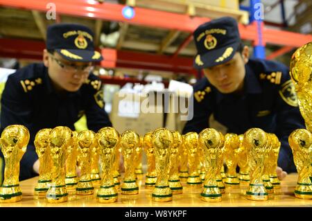 Les agents des douanes chinoises vérifier fake World Cup trophées qu'ils ont saisi dans un entrepôt dans la ville de Yiwu, province de Zhejiang, Chine de l'est le 24 avril 2014. 18 860 Banque D'Images