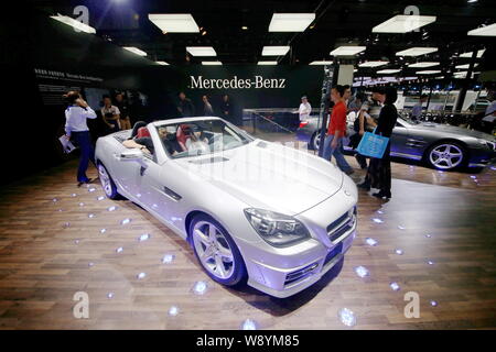 --FILE--visiteurs essayer ou regarder une Mercedes-Benz SLK 200 Voiture de sport de l'afficheur pendant la 12ème Chine (Shanghai) International Automobile Exhibitio Banque D'Images