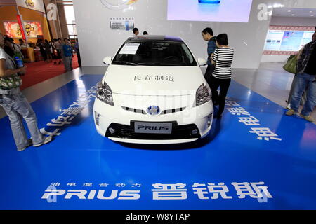 --FILE--visiteurs regarder une voiture hybride Toyota Prius au cours de l'Asie du nord-est de l'investissement et du Commerce de l'Expo 2012 dans la ville de Changchun, Jilin, Chine du nord-est Banque D'Images