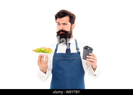 Cafe food concept. Homme garçon barbu tablier porter porter la plaque avec la nourriture et tasse à café. De délicieux croissants. Profitez de votre repas. Guy servant un croissant fourré la laitue et les légumes frais. Alimentation saine. Banque D'Images