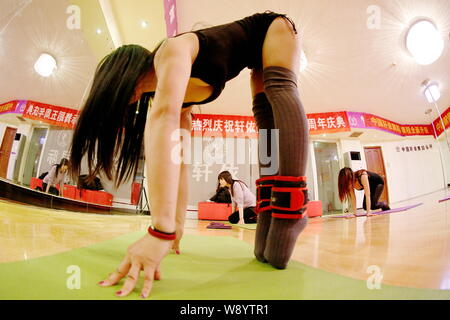 Professeur de danse pôle chinois Liu Guims, avant, dirige ses étudiants de pratiquer pole dancing à un centre de formation de danse à Zhengzhou city, central C Banque D'Images