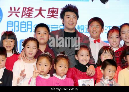 Le pianiste chinois Lang Lang, centre arrière, pose avec de jeunes enfants au cours d'une conférence de presse pour le concert de Shenyang en Chine de son à Shenyang city, n Banque D'Images