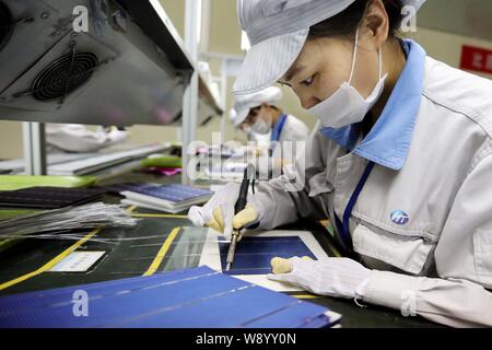 --FILE--femelle à souder les travailleurs chinois pour les cellules photovoltaïques des panneaux solaires à l'usine de Shanghai Nouvelle Shenzhou Energy Development Co., Ltd. à Ganyu co Banque D'Images