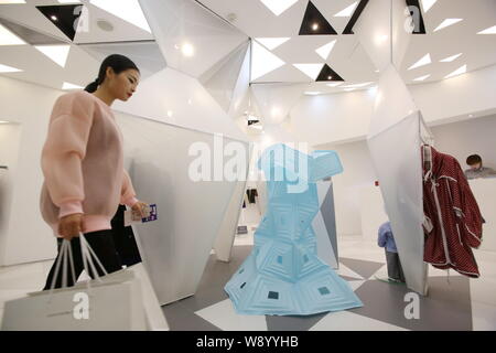 Un client qui passe devant une oeuvre sur l'affichage à l'intérieur d'un magasin de mode pendant la conception votre style d'affichage fenêtre croisé exposition à Xintiandi à Sha Banque D'Images