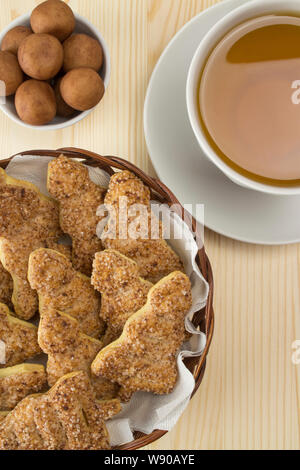 Une tasse de thé, massepain bonbons et biscuits en forme d'une nouvelle année. arbre blanc thé vert dans le porridge, massepain maison ronde des bonbons, du sucre bouffées h Banque D'Images