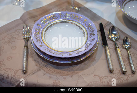 Plaque violet lilas avec couverts sur une serviette en lin. Réglage de la table. Plaque rugueuse couteau fourchette cuillère à dessert couverts. La table de fête blanc couvert tablec Banque D'Images