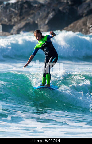 Une femelle à surfer une vague de Fistral Newquay en Cornouailles. Banque D'Images