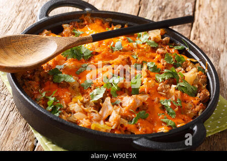 Casserole de chou allemand avec du boeuf haché, tomates, oignons et fromage cheddar, close-up dans une casserole sur la table horizontale. Banque D'Images