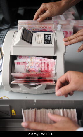 --FILE--un greffier chinois utilise une machine de comptage de caisse à compter de RMB (renminbi) yuan billets à une succursale de la Banque agricole de Chine à Qionghai city Banque D'Images