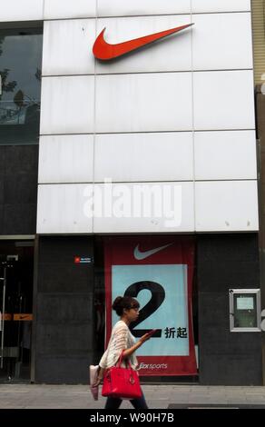 --FILE--un piéton passe devant un magasin de vêtements de sport Nike en Yichang city, province de Hubei, Chine centrale 2 mai 2013. Chef de la marque Nike Banque D'Images