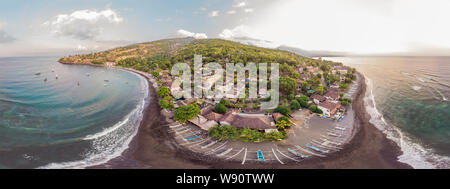 Vue aérienne de la plage d'Amed à Bali, Indonésie. Bateaux de pêche traditionnelles appelées jukung sur la plage de sable noir et le Mont Agung volcan de la Banque D'Images