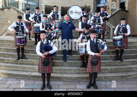 Glasgow, Royaume-Uni. Août 12, 2019. Glasgow international piping festival a fêté aujourd'hui avec une performance spéciale de l'incendie et de sauvetage écossais juvénile Novice Pipe Band. Maintenant dans sa 16e année, le vivre, est le plus grand festival du genre à attirer 40 000 fans de musique, les familles et les fans de partout dans le monde à regarder plus de 5 000 Pipers effectuer à 150 événements dans toute la ville. Image de RODDY MACLEOD, Directeur du Festival avec la bande. Credit : Findlay/Alamy Live News Banque D'Images