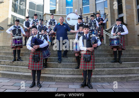 Glasgow, Royaume-Uni. Août 12, 2019. Glasgow international piping festival a fêté aujourd'hui avec une performance spéciale de l'incendie et de sauvetage écossais juvénile Novice Pipe Band. Maintenant dans sa 16e année, le vivre, est le plus grand festival du genre à attirer 40 000 fans de musique, les familles et les fans de partout dans le monde à regarder plus de 5 000 Pipers effectuer à 150 événements dans toute la ville. Image de RODDY MACLEOD, Directeur du Festival avec la bande. Credit : Findlay/Alamy Live News Banque D'Images