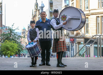 Glasgow, Royaume-Uni. Août 12, 2019. Glasgow international piping festival a fêté aujourd'hui avec une performance spéciale de l'incendie et de sauvetage écossais juvénile Novice Pipe Band. Maintenant dans sa 16e année, le vivre, est le plus grand festival du genre à attirer 40 000 fans de musique, les familles et les fans de partout dans le monde à regarder plus de 5 000 Pipers effectuer à 150 événements dans toute la ville. Photo de EMILY GORMLEY âgés de 11 à la batterie et Eddie McCLUSKEY âgés de 17 grosse caisse sur withnRODDY MacLEOD, directeur du Festival Crédit : Findlay/Alamy Live News Banque D'Images