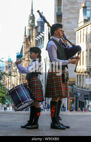 Glasgow, Royaume-Uni. Août 12, 2019. Glasgow international piping festival a fêté aujourd'hui avec une performance spéciale de l'incendie et de sauvetage écossais juvénile Novice Pipe Band. Maintenant dans sa 16e année, le vivre, est le plus grand festival du genre à attirer 40 000 fans de musique, les familles et les fans de partout dans le monde à regarder plus de 5 000 Pipers effectuer à 150 événements dans toute la ville. Photo de EMILY GORMLEY âgés de 11 à la batterie et Gavin Mackenzie âgés de 16 ans sur les tuyaux. Credit : Findlay/Alamy Live News Banque D'Images