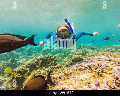 Femme heureuse dans la plongée sous-marine plongée masque avec les poissons tropicaux dans la mer de corail Extérieure. L'eau de vie, voyage d'aventure en plein air sport, natation Banque D'Images