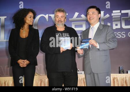 Le réalisateur français Luc Besson, au centre, pose avec le DVD de son film, à la maison, alors que son producteur épouse Virginie Besson-Silla, gauche, le regarde pendant une p Banque D'Images