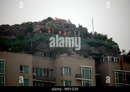 Les travailleurs chinois détruire le Rock Garden à la montagne villa, qui est construit par le professeur Zhang Beiqing sur le toit de son immeuble à Banque D'Images