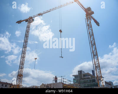 Site de construction en France d'un immeuble de bureaux, avec scaffholdings, l'acier et les façades en verre et des blocs de ciment, ainsi que deux grues visibles, dans un Banque D'Images