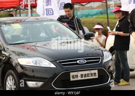 --FILE--visiteurs chinois regarder une Ford Mondeo lors d'une auto show de la ville de Qingdao, province du Shandong, Chine de l'est 5 mai 2012. FORD MOTOR CO dit th Banque D'Images