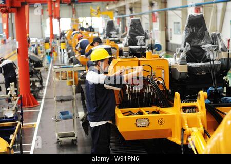 --FILE--travailleurs chinois excavatrices assemblage sur la chaîne de montage dans une usine de Foton Lovol lourd International Co., Ltd. dans la ville de Qingdao, EAS Banque D'Images