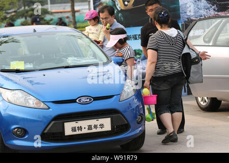 --FILE--visiteurs chinois regarder une Ford Fiesta au cours d'une auto show de la ville de Qingdao, province du Shandong, Chine de l'est 5 mai 2012. FORD MOTOR CO dit th Banque D'Images