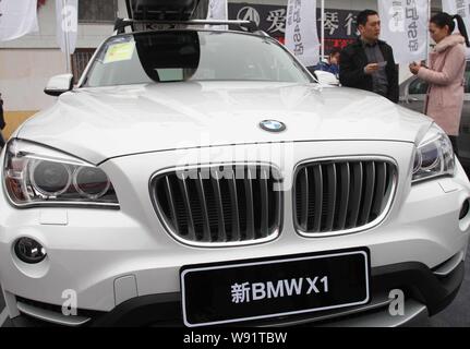 --FILE--visiteurs regarder une voiture BMW X1 au cours d'une exposition internationale de l'automobile dans la région de Xuchang, province de Henan Chine centrale, 17 mars 2013. À l'intérieur Banque D'Images