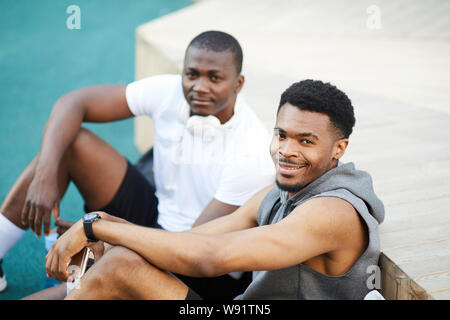 High angle portrait de deux gars afro-américaines smiling at camera tandis que le refroidissement en skate park en plein air, copy space Banque D'Images