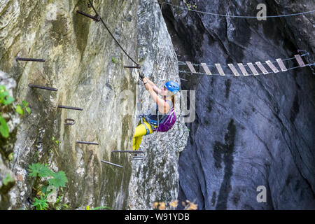 Ambiance fille en bas de l'escalade via ferrata une section sur une route appelée 'Postalmklamm', dans la gorge de Postalm, Haute Autriche, et se dirigeant vers un faux-st Banque D'Images