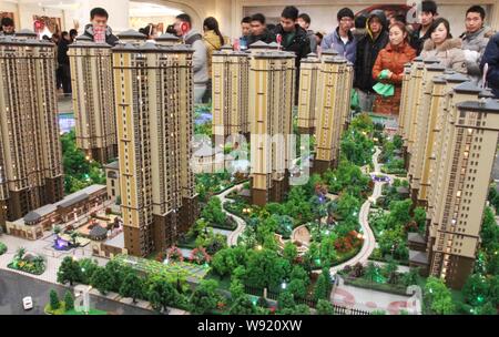 --FILE--acheteurs potentiels regarder une maquette d'un nouvel ensemble résidentiel à un bureau de vente dans la ville de Xuchang, province de Henan, Chine centrale de 23 Banque D'Images