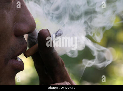 --FILE--un Chinois fume sur un chantier dans la ville de Shuangyashan, province de Heilongjiang, Chine du nord-est, le 11 septembre 2012. Chines de réglementation du tabac Banque D'Images