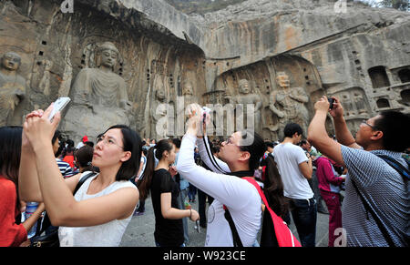 --FILE--touristes de prendre des photos des Grottes de Longmen durant la journée nationale de vacances à Luoyang, Chine centrale dans la province du Henan, le 4 octobre 2013. A ne Banque D'Images