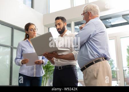 Homme barbu concentré à regarder son ordinateur portable Banque D'Images