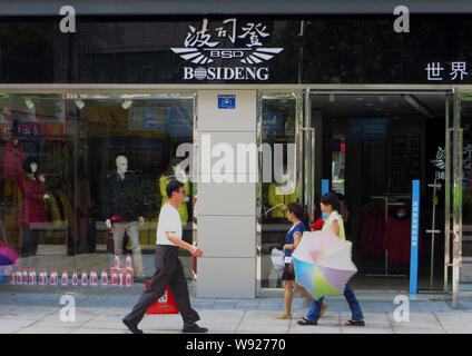 --FILE--piétons devant une boutique de vêtements bas de Bosideng à Yichang city, province de Hubei, Chine centrale 18 septembre 2013. Globetrotters chinois Banque D'Images