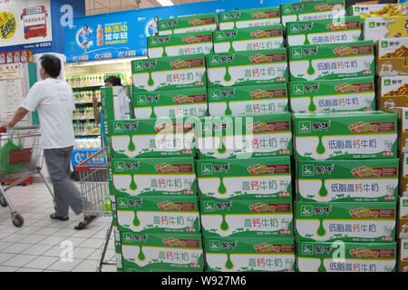 --FILE--un client entre cours des cartons de lait Mengniu dans un supermarché à Haikou, province de Hainan, Chine du Sud 21 juin 2013. China Mengniu Dairy, C Banque D'Images