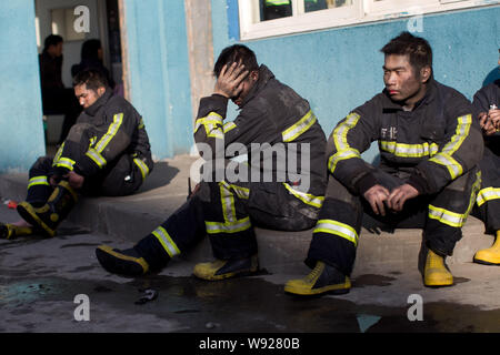 Les pompiers chinois reste comme ils essaient d'éteindre le feu à l'usine de Hangzhou Yusei Machinery Co., Ltd. à Xiaoshan Hangzhou city, est de la Chine Banque D'Images