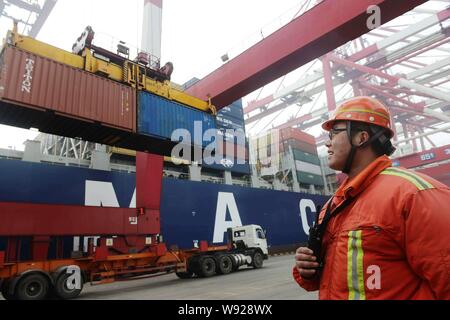 --FILE--Un travailleur chinois dirige une grue pour soulever les conteneurs dans le port de Qingdao en Qingdao, Chine de l'est la province de Shandong, 14 février 2013. Banque D'Images