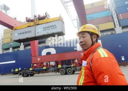 --FILE--Un travailleur chinois dirige une grue pour soulever Mærsk conteneurs au port de Qingdao en Qingdao, Chine de l'est la province de Shandong, 14 février Banque D'Images